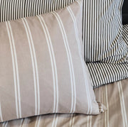 Martini olive striped cotton duvet cover styled on a bed with matching pillows